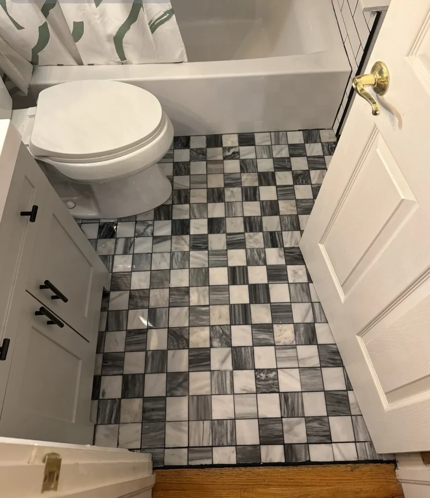 Bathroom rebuilt with new tile floor, tub and vanity after water damage – Denver, CO
