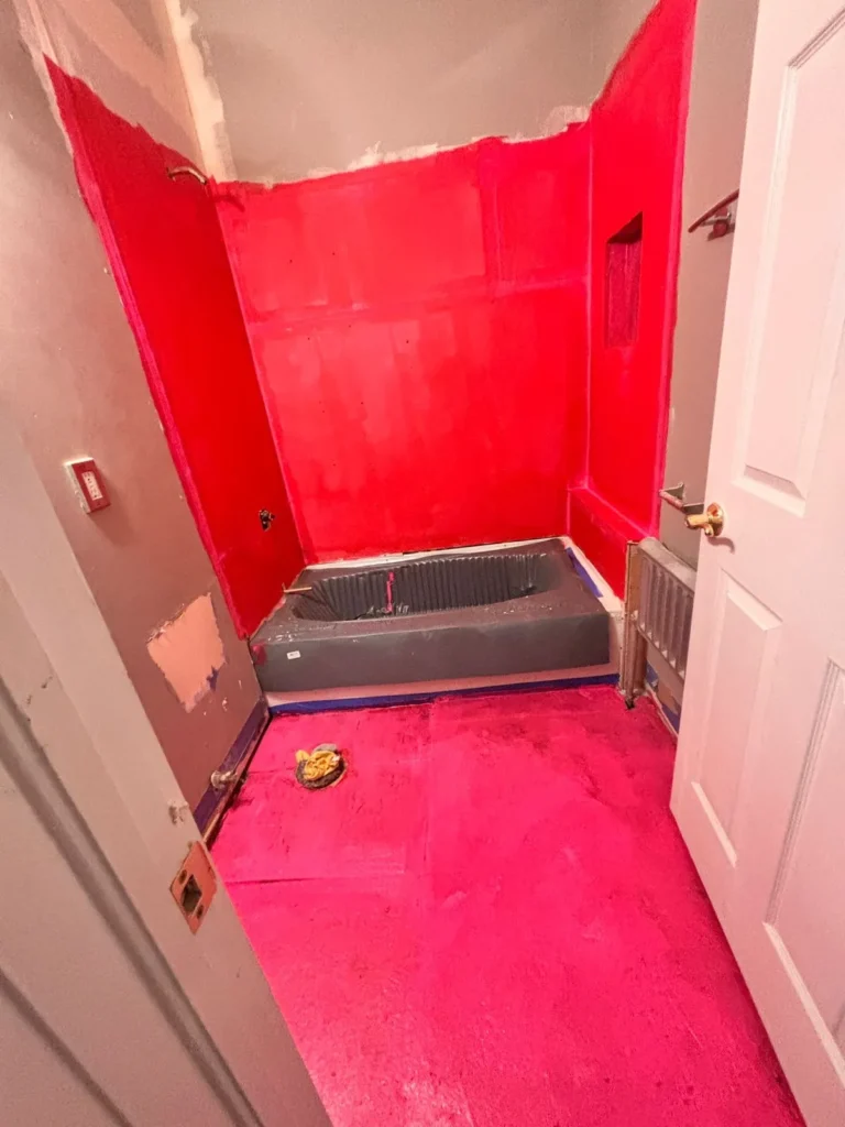 Waterproofing membrane applied to bathroom walls and floor during a water damage rebuild – Denver, CO